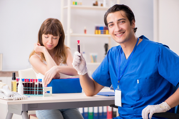 male doctor with vile of blood from female patient male doctor with vile of blood from female patient