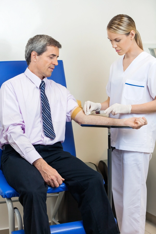 mature businessman undergoing blood test at hospital