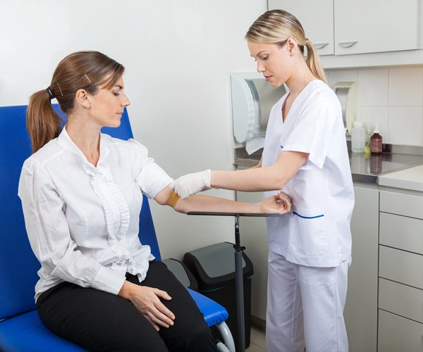 nurse preparing businesswoman for blood test in hospital
