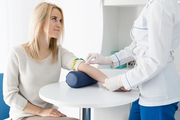 nurse takes blood sample from female patient 2