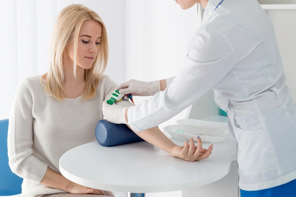 nurse takes blood sample from female patient