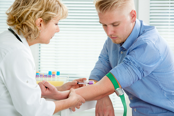 nurse taking blood sample from male patient at the doctors office nurse taking blood sample from male patient at the doctors office