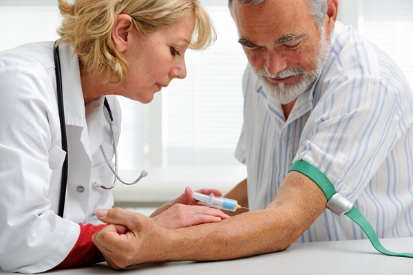 nurse with syringe is taking blood for test at the doctor office 2