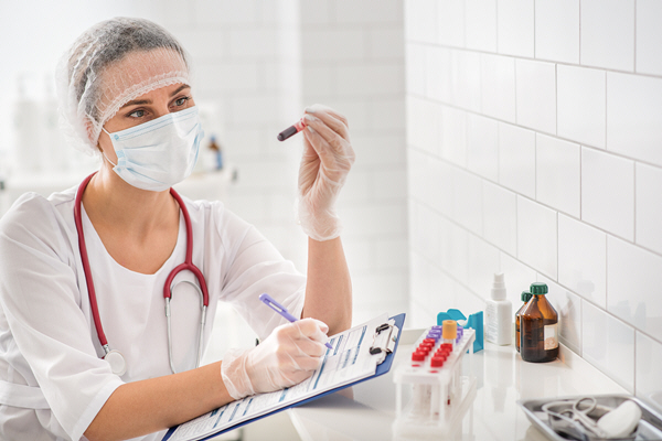 pensive female doctor is observing blood sample in laboratory pensive female doctor is observing blood sample in laboratory