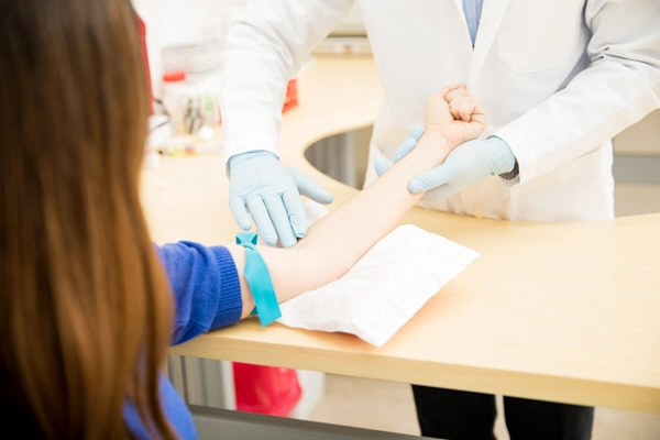 point of view of a female patient getting a blood test in a clinical laboratory