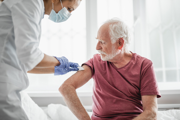 portrait of bearded old man receiving shot portrait of bearded old man receiving shot