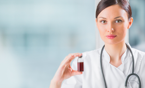 portrait of pretty female laboratory assistant analyzing a blood sample at hospital portrait of pretty female laboratory assistant analyzing a blood sample at hospital