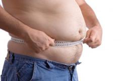 Fat man holding a measurement tape against white background